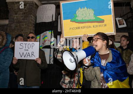 Londra, Inghilterra, Regno Unito 26 febbraio 2022 centinaia di persone si riuniscono fuori dall’Ambasciata russa in solidarietà con l’Ucraina per protestare contro l’invasione del paese da parte della Russia. I manifestanti scrivono messaggi sul muro dell'ambasciata e lasciano segni attaccati alle porte e alle ringhiere Foto Stock
