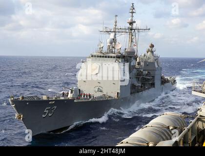 MAR DELLE FILIPPINE (Feb 26, 2022) l'incrociatore missilistico guidato di classe Ticonderoga USS Mobile Bay (CG 53) naviga accanto alla portaerei di classe Nimitz USS Abraham Lincoln (CVN 72) per condurre un rifornimento in mare. Abraham Lincoln Strike Group è in fase di implementazione pianificata nell'area delle operazioni della flotta USA 7th per migliorare l'interoperabilità attraverso alleanze e partnership, fungendo da forza di risposta pronta a supportare una regione indopacifica libera e aperta. (STATI UNITI Foto Navy di SMass Communication Specialist Seaman Aleksandr Freutel) Foto Stock