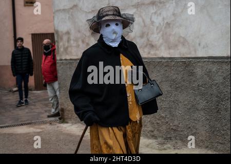 Luzon, Spagna. 26th Feb 2022. Una donna con il viso coperto da un panno bianco e con un abito tradizionale, noto come 'mascaritas', è vista durante una tradizionale festa di carnevale. Ogni anno, il piccolo villaggio di Luzon, a Guadalajara, ospita un festival di carnevale chiamato 'Diablos y Mascaritas' (Devils e maschere). Il carnevale si ritiene che risalga all'epoca celtica, anche se il primo riferimento scritto che documenta il Carnevale di Luzon risale al 14th secolo. Credit: Marcos del Maio/Alamy Live News Foto Stock