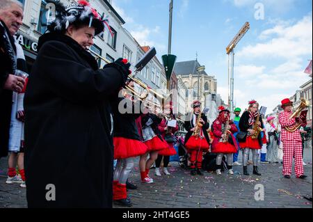 Una band musicale suona musica tradizionale olandese di fronte alle persone che indossano costumi. Il Carnevale nei Paesi Bassi, noto anche come "Carnaval", è una celebrazione di tre giorni molto famosa nella regione cattolica meridionale dei Paesi Bassi. Quest'anno è nuovamente celebrato, ma perché i numeri di infezione di Coronavirus sono ancora alti e alcune restrizioni sono state imposte. Le grandi sfilate sono state sospese, ma le feste per le strade e i pub possono essere celebrate. Durante il Carnevale la città di Breda prende il nome simbolico di Kielegat, e le strade sono decorate con colori rosso e arancione. Foto Stock