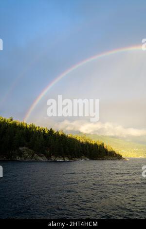 Doppio arcobaleno all'ora d'oro tramonto arcobaleno foresta alberi. North Vancouver, British Columbia Foto Stock