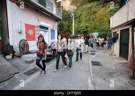 Gli adolescenti camminano attraverso un vicolo sull'isola di Cijin, il distretto di Cijin, Kaohsiung, Taiwan Foto Stock