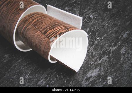 Linoleum. Rotolo di linoleum su sfondo nero. Rivestimenti per pavimenti. Posa di rivestimenti per pavimenti. Tessitura di legno su un rotolo. Il campione viene arrotolato. Foto Stock
