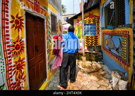 Kolkata, India. 26th Feb 2022. Un uomo ha visto camminare attraverso una strada colorata.le strade di Kolkata e le baraccopoli diverse visto essere dipinta con graffiti colorati come un'iniziativa di un festival permanente dell'arte (Behala Art Fest) a Kolkata. Artisti provenienti da diversi college d'arte hanno partecipato per rendere la città più bella. Credit: SOPA Images Limited/Alamy Live News Foto Stock