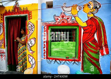 Kolkata, India. 26th Feb 2022. Scena della vita quotidiana in un ambiente colorato di slum con splendidi graffiti alle pareti. Le strade di Kolkata e le baraccopoli diverse sono viste come dipinte con graffiti colorati come un'iniziativa di un continuo Art Fest (Behala Art Fest) a Kolkata. Artisti provenienti da diversi college d'arte hanno partecipato per rendere la città più bella. Credit: SOPA Images Limited/Alamy Live News Foto Stock