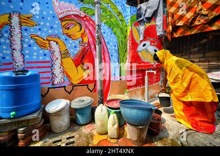 Kolkata, India. 26th Feb 2022. Scena della vita quotidiana in un ambiente colorato di slum con splendidi graffiti alle pareti. Le strade di Kolkata e le baraccopoli diverse sono viste come dipinte con graffiti colorati come un'iniziativa di un continuo Art Fest (Behala Art Fest) a Kolkata. Artisti provenienti da diversi college d'arte hanno partecipato per rendere la città più bella. (Foto di Avishek Das/SOPA Images/Sipa USA) Credit: Sipa USA/Alamy Live News Foto Stock