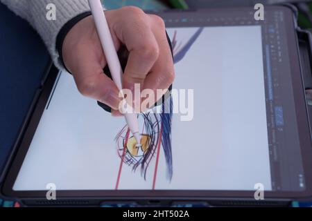 Giovane artista che disegnano gli occhi di un personaggio cartoon Foto Stock