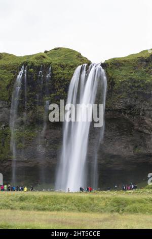 Colpo verticale di gente radunata intorno ad una cascata Foto Stock