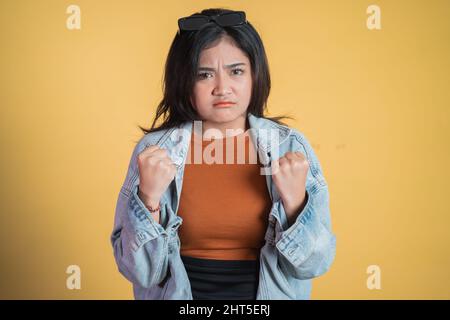 triste giovane donna che stringe le mani mentre arrabbiato Foto Stock