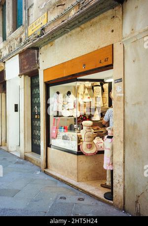 Front entrance of a small shop selling shirts and bags in the city center. Foto Stock