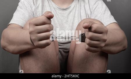 mani di un uomo in manette, punizione per un crimine penale record... Foto Stock