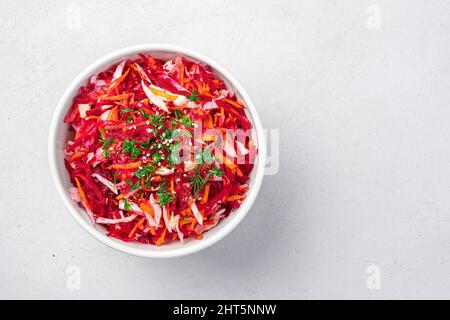 Insalata estiva vitaminica con barbabietole, cavoli e carote su sfondo grigio chiaro. Foto Stock