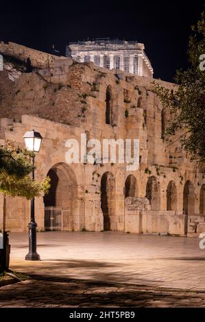 Vista ad angolo basso del Partenone di notte all'Acropoli di Atene, Grecia. Odeon di Erode Attico è visibile in primo piano Foto Stock