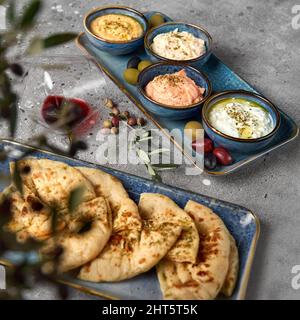 Hummus, Tzatziki servito con pane pita. La Grecia e il Mediterraneo si tuffa e si diffonde. Cucina tradizionale classica turca e greca Foto Stock