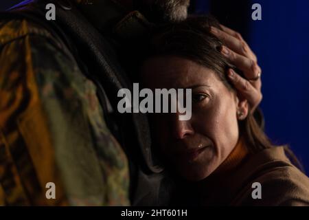 Primo piano di donna triste piangendo quando abbraccia il suo marito militare e salutandolo. Foto Stock