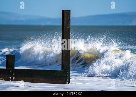Le onde si infrangono verso l'inguine di legno Foto Stock