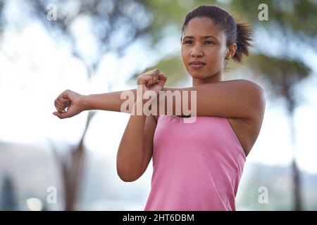 Assicurandosi che i suoi muscoli siano pronti per la corsa. Un giovane adolescente che si riscalda per la corsa in avanti. Foto Stock