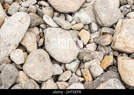 Sfondo di ciottoli grigi di diverse dimensioni sulla spiaggia Foto Stock