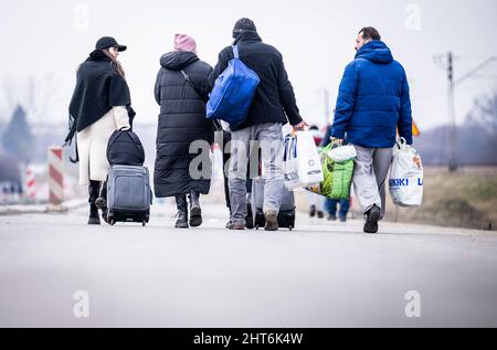 Przemysl, Polonia. 27th Feb 2022. I rifugiati ucraini camminano da Shehyni in Ucraina a Medyka in Polonia dopo aver attraversato il confine. Molti ucraini lasciano il paese dopo azioni militari da parte della Russia sul territorio ucraino. Credit: Michael Kappeler/dpa/Alamy Live News Foto Stock