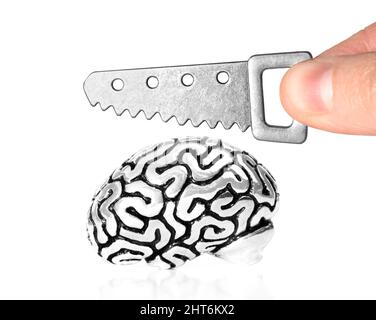 Segare una copia anatomica in miniatura di un cervello umano con una piccola sega isolata su sfondo bianco. Concetto di difficoltà di relazione. Foto Stock