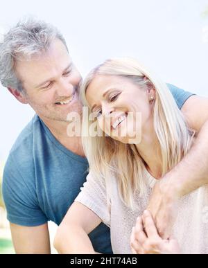 Abbracciando sua bella moglie. Una coppia matura affettuosa che si gode una giornata nel parco insieme. Foto Stock