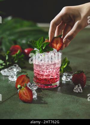 Limonata fresca con ghiaccio, menta e fragola. Tè freddo con fragole e menta. Su sfondo bianco. Messa a fuoco selettiva Foto Stock