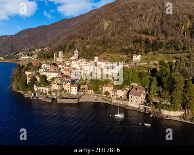 VISTA AEREA. Foto panoramica, vista da cartolina dal lago di un piccolo borgo antico in Lombardia, Lago di Como, Italia Foto Stock