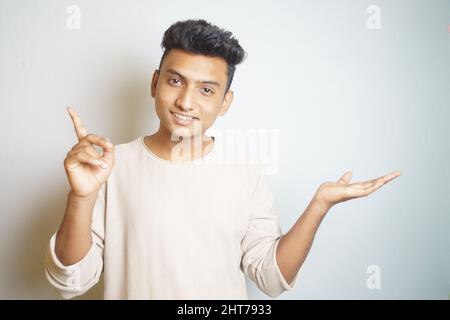 Uomo indiano che finge di tenere qualcosa e che punta in su Foto Stock