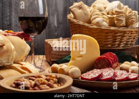 Tavolo in legno con molti tipi di gustosi antipasti e vino Foto Stock