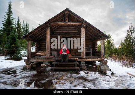 Seduto sul portico di Snow Peak Cabin Colville National Forest Foto Stock
