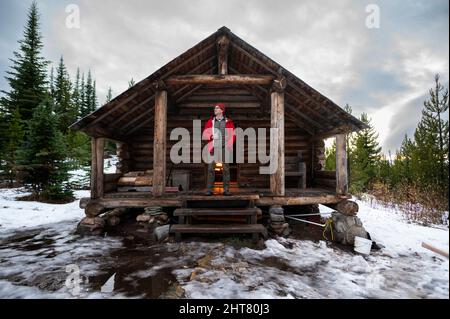 Bere una birra sulla veranda Snow Peak Cabin nella Colville National Forest Foto Stock