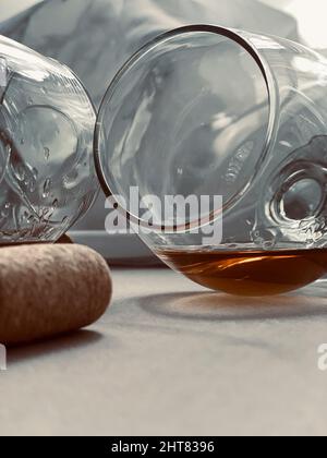 bicchiere sul lato con whiskey e sughero Foto Stock