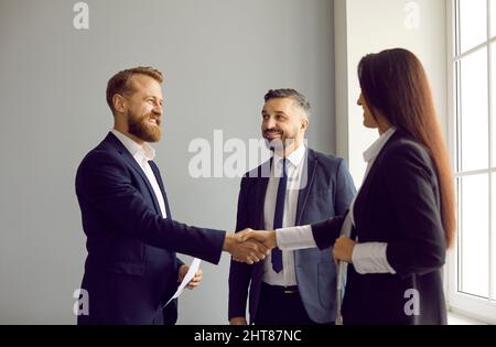 Due professionisti felici di affari che fanno l'affare di collaborazione e scambiano i handshake Foto Stock