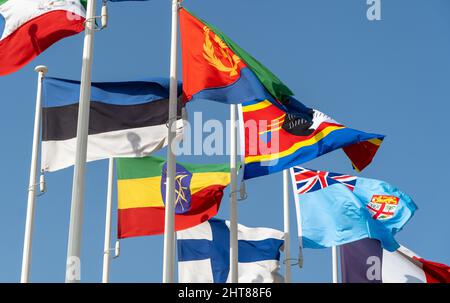 Primo piano delle bandiere del mondo che volano in fila al di fuori del centro fieristico nel 2020 ondeggiando su sfondo azzurro del cielo (Etiopia, Finlandia, Eswantini, Estonia) Foto Stock