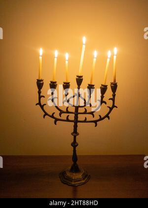 Primo piano di uno splendido candelabro a sette ramificazioni con candele accese sul tavolo di legno Foto Stock