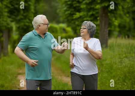 Felice uomo e donna anziana che si gode di un allenamento attivo in un parco estivo verde Foto Stock