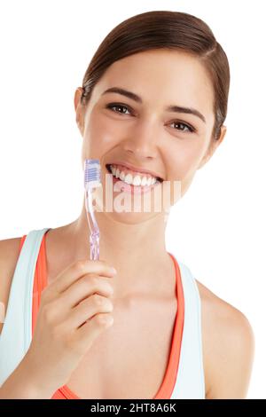 Datevi qualcosa di cui sorridere. Bella ragazza che tiene lo spazzolino e sorridente. Foto Stock