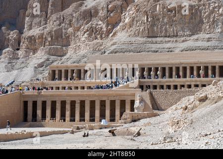 Luxor, Egitto - 15 febbraio 2022: Vista del tempio della regina Hatshepsut nelle montagne dell'Egitto. Le persone camminano intorno al territorio e ispezionano la A. Foto Stock