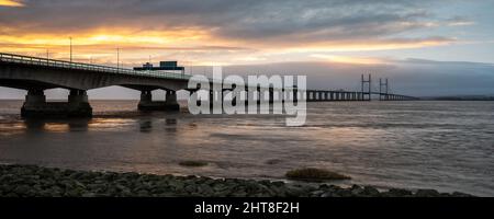 Sunset illumina il cielo sul secondo ponte Severn Crossing sul canale di Bristol. Foto Stock