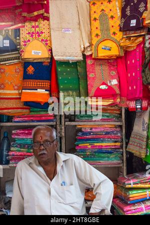 Il proprietario del negozio vende tessuto, Chandni Chowk (piazza Moonlight), Delhi, India Foto Stock