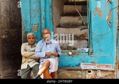 Vecchi uomini seduti per strada, Chandni Chowk (Piazza del chiaro di luna), Delhi, India Foto Stock