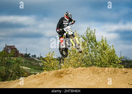 Pilota professionista con un casco in una gara di motocross su una pista di sabbia a Marysville, California Foto Stock