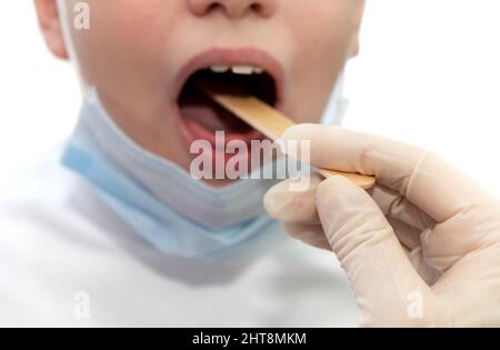 La mano del medico in guanti di gomma esamina la bocca di un bambino malato. Il medicinale. Medico dei bambini Foto Stock