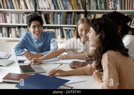 Distratto felice studenti diversi divertirsi in biblioteca. Foto Stock