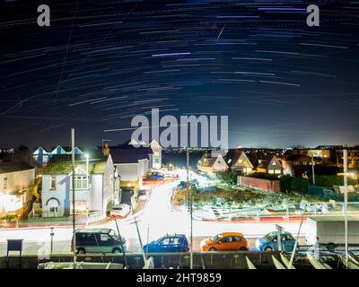 Sheerness, Kent, Regno Unito. 27th Feb 2022. Tempo UK: Sentieri stellari che mostrano la rotazione della terra, tra cui una "stella di tiro" (forma di diamante vicino al centro in alto) in una serata limpida ma fredda sopra Sheerness nel Kent. Fig.: Vista verso il cielo meridionale. (Esposizione prolungata, composizione integrata nella fotocamera di circa 25 minuti). Credit: James Bell/Alamy Live News Foto Stock