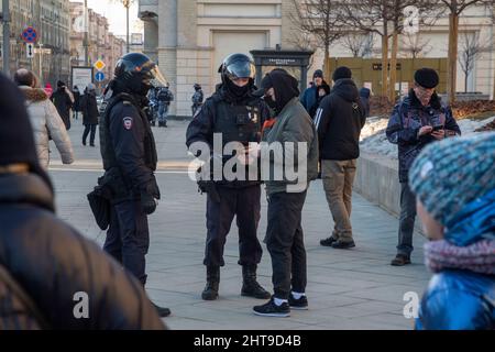 Mosca, Russia. 27th febbraio 2022 gli ufficiali di polizia controllano il passaporto di un passeggero sulla via Tverskaya nel centro di Mosca, Russia Foto Stock