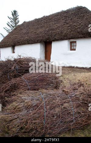 Cottage con tetto in paglia nel villaggio di Plockton sulle rive di Loch Carron nelle Highlands della Scozia Foto Stock