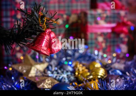 Campane rosse appese a un ramo di un albero di Natale Foto Stock