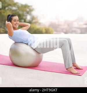 Adatta corpo, mente felice. Ritratto completo di una giovane donna che fa yoga all'aperto. Foto Stock