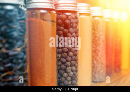 Spezie ed erbe di diversi colori in piccoli vasi. Messa a fuoco soft selettiva. Foto Stock